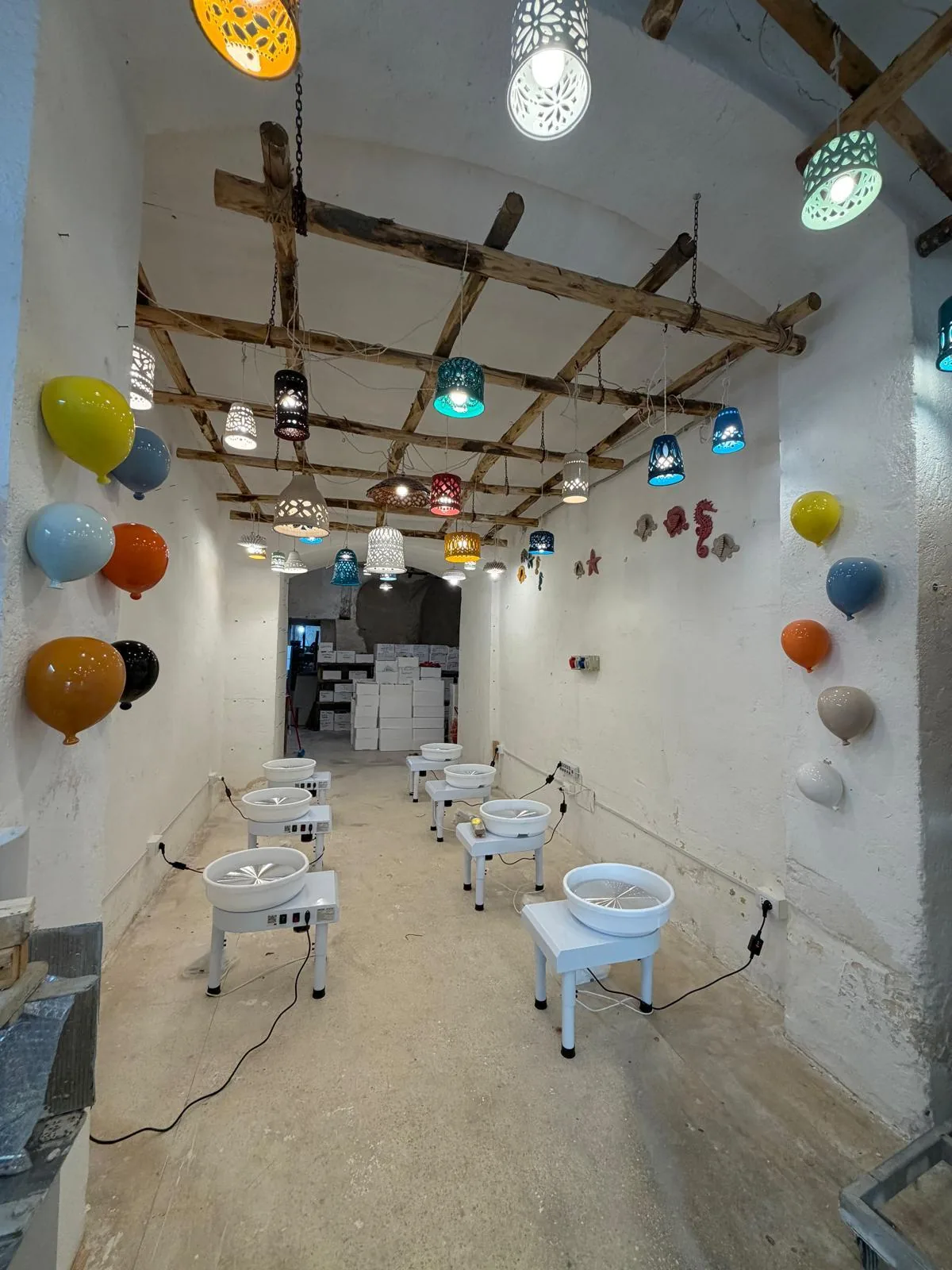 Il laboratorio di Rosa Academy, con le ceramiche colorate appese alle pareti